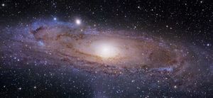 At 2.5 million light-years away, the Andromeda Galaxy is one of the farthest objects visible to the naked eye. If there were life in this galaxy, and if they were to look at Earth through a telescope, they would see a planet not yet inhabited by humans.