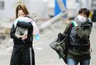 Two women walk in a tsunami devastated street in Hishonomaki, Miyagi prefecture on March 15, 2011.  Japan's government on March 15 urged people against panic-buying of food and supplies, as the country grapples with an earthquake and tsunami and resulting nuclear crisis.