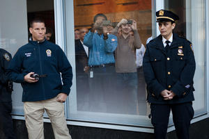 Workers at the Bank of America building in midtown take photos of Occupy Wall Street protestors as police guard the perimeter, Friday, Oct. 28, 2011, in New York. Nearly 400 Occupy&nbsp;Wall&nbsp;Street protesters carried what they said were 7,000 letters of complaint to offices of banks they accuse of corporate greed. 