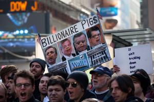 Occupy Wall Street demonstrators carry signs through New York's Times Square during a march on banks in the midtown area, Friday, Oct. 28, 2011. Nearly 400 Occupy Wall Street protesters carried what they said were 7,000 letters of complaint to offices of banks they accuse of corporate greed. 